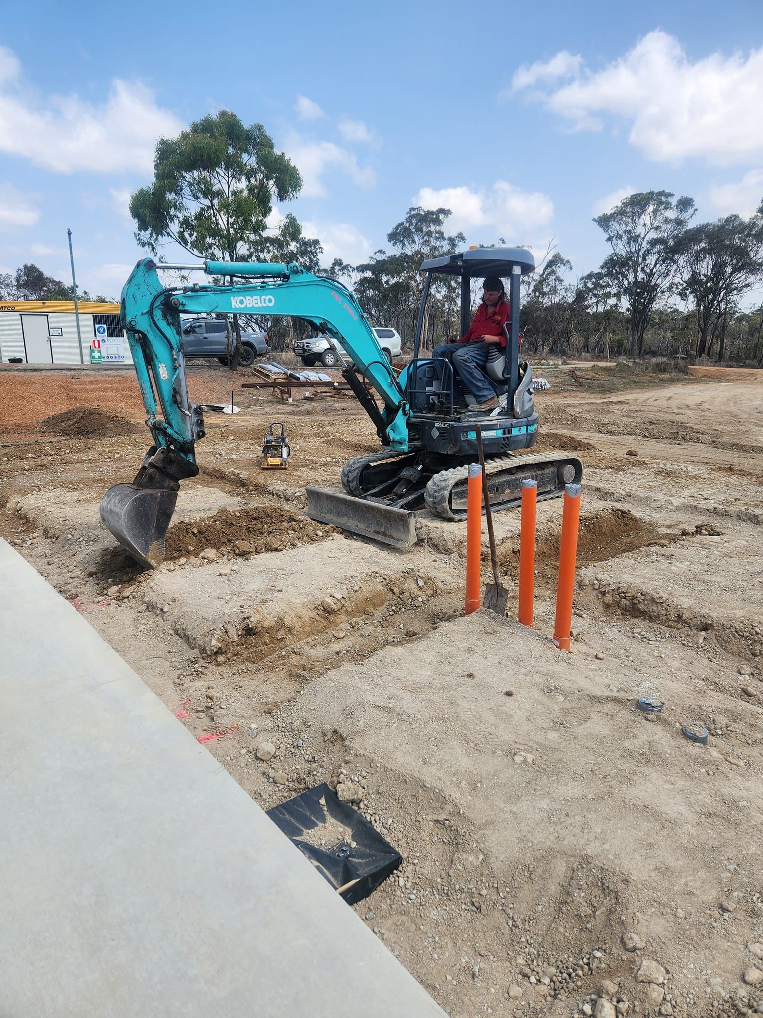 Small Turquoise Excavator Digging in a Dirt Construction Site — AGM HIRE NQ in Kirwan, QLD