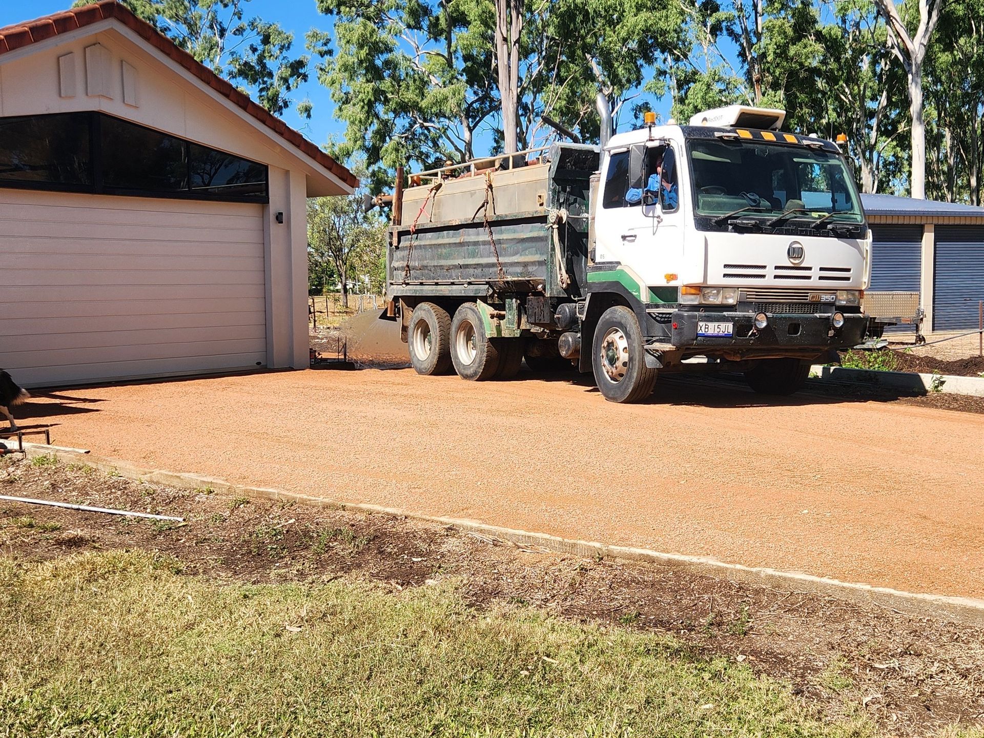 Truck Delivering Gravel to a Driveway Next to a Garage — AGM HIRE NQ in Condon, QLD
