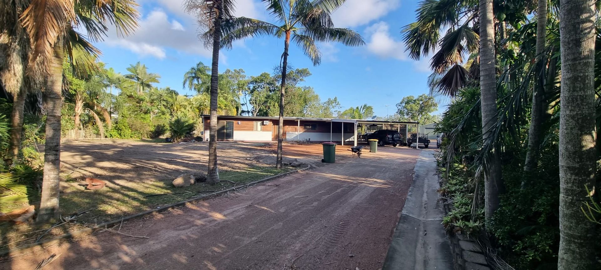 Dirt Road Leading to a Building With Palm Trees on Either Side — AGM HIRE NQ in Condon, QLD
