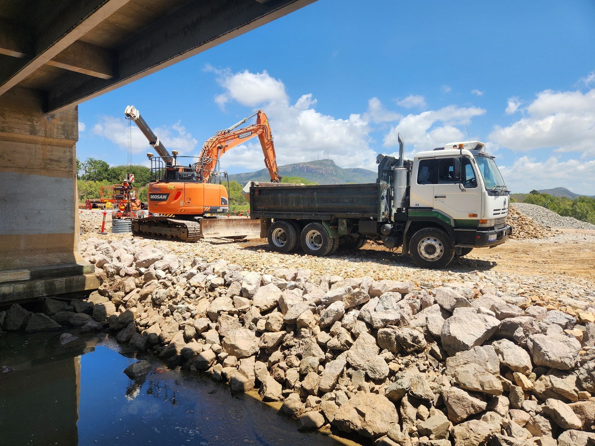 An Excavator Loading a Dump Truck at a Construction Site — AGM HIRE NQ in Condon, QLD