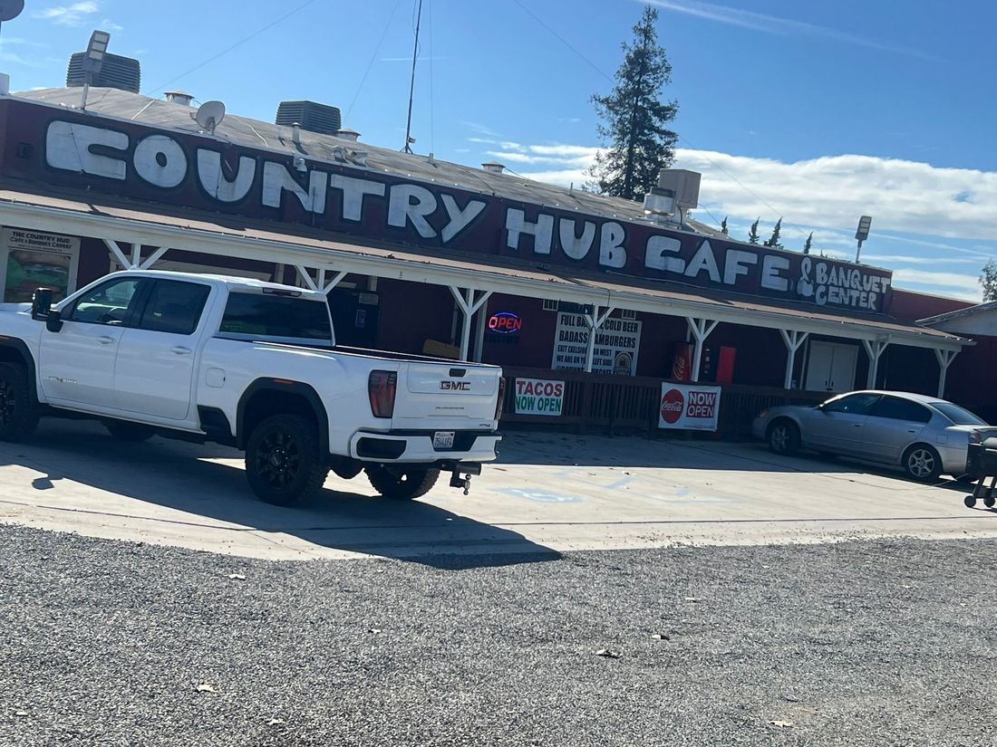 Country Hub Cafe storefront with white pickup truck parked outside under a clear blue sky