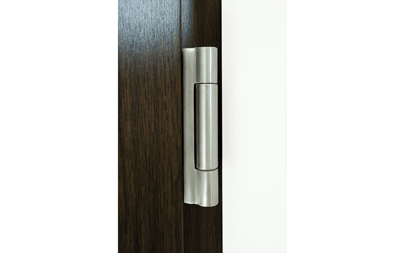 Primo piano della cerniera di una porta di legno.