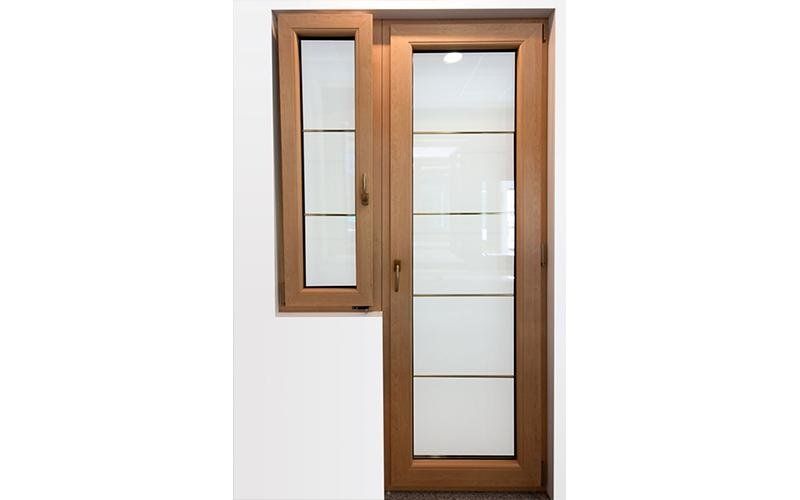 Una porta di legno con una finestra accanto su un muro bianco.