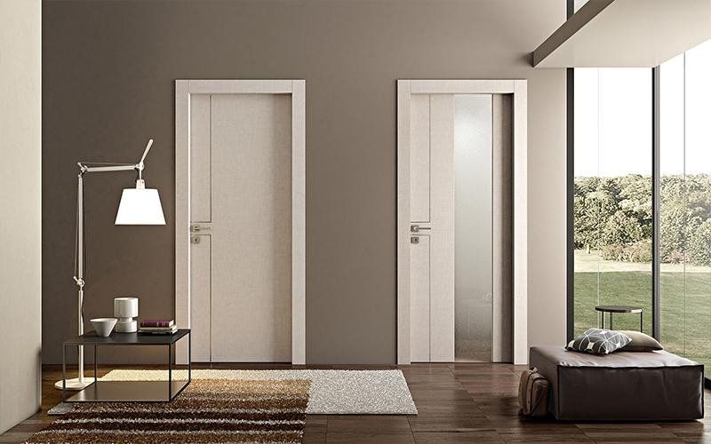 Un soggiorno con due porte bianche e una lampada.