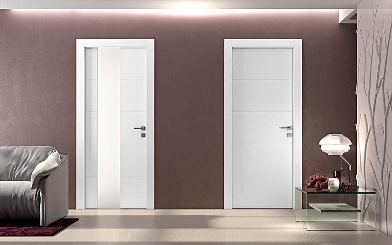 Un soggiorno con due porte bianche e un divano