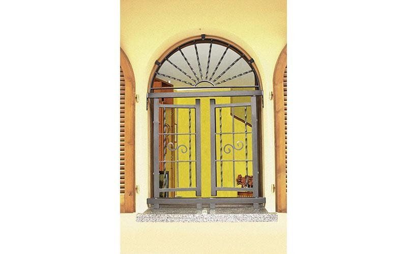 Una finestra con una grata in ferro battuto