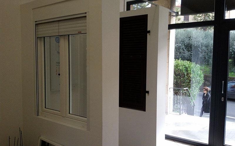 Una stanza con una finestra e una porta nera.