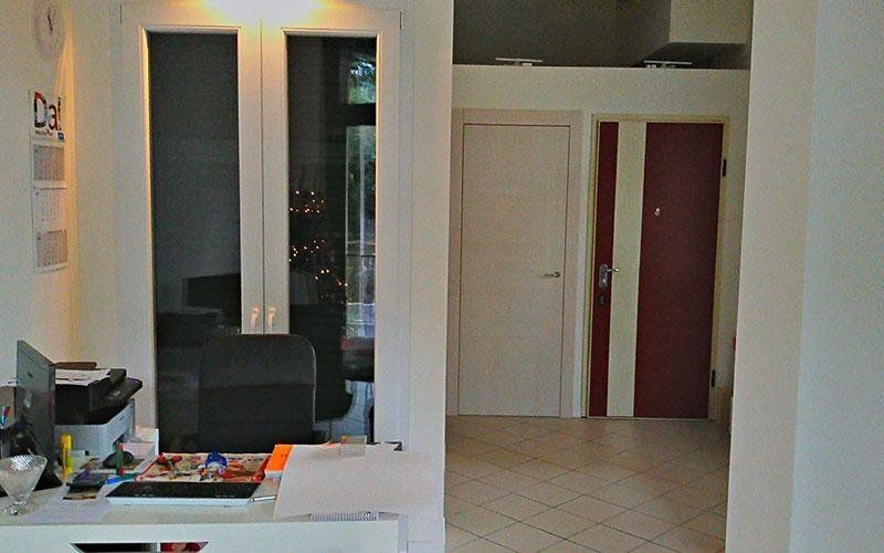 Una stanza con una scrivania e una porta rossa