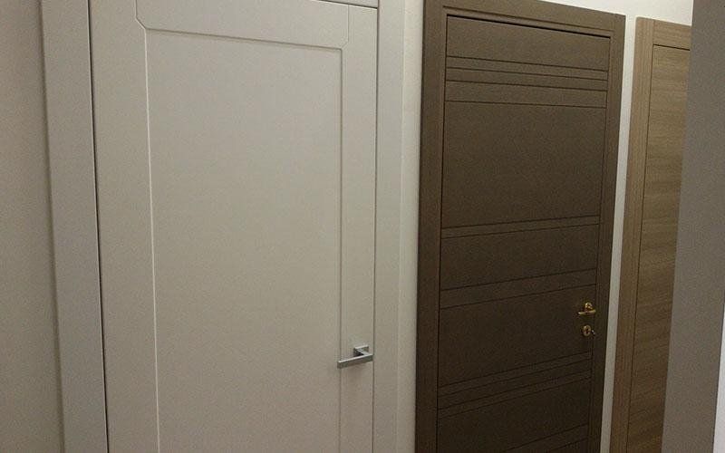 Una fila di porte sono allineate una accanto all'altra in una stanza.