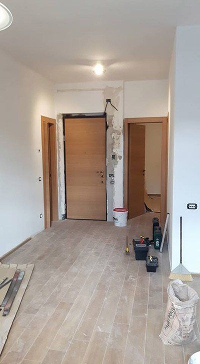 Un soggiorno con pavimento in legno e porta in legno.