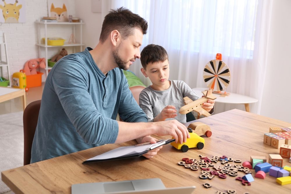 Therapist and the Boy at the Table Playing With Toys — Bright Day Psychology in Pialba, QLD
