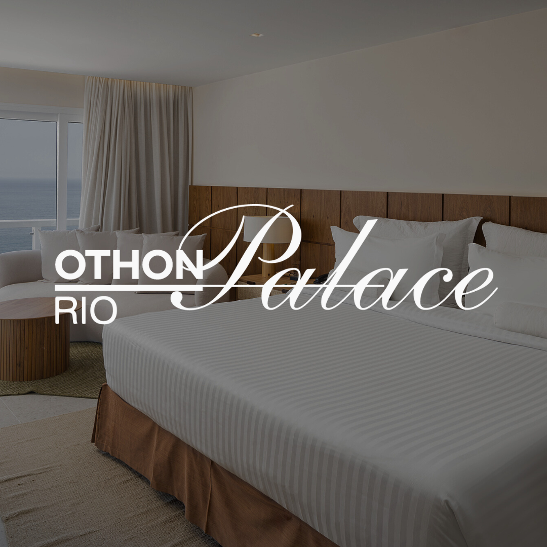 Interior de quarto de hotel com cama, sofá e vista para o mar; logotipo do Othon Palace Rio sobreposto.