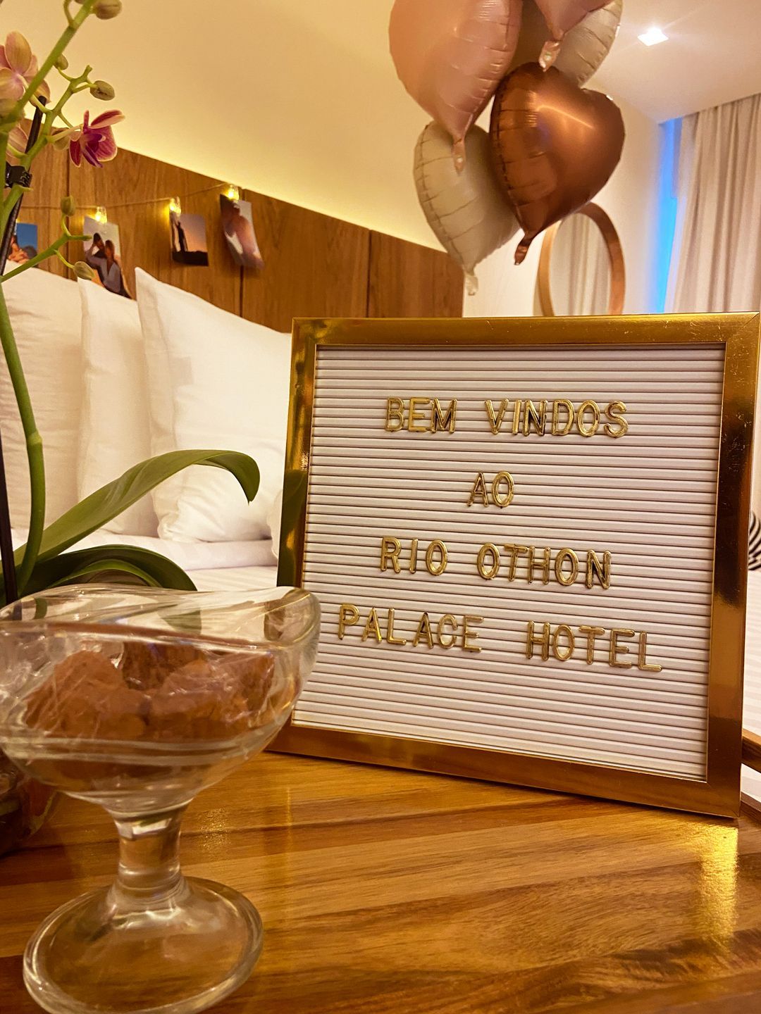 Uma cama com um vaso de rosas vermelhas em cima