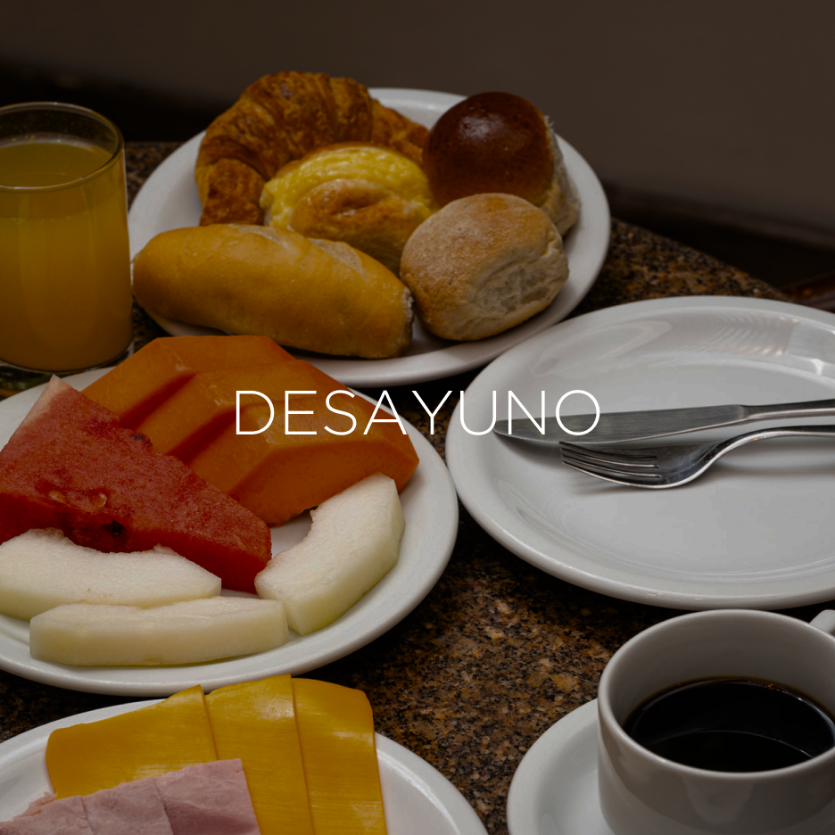 Café da manhã completo com café, suco, doces, frutas e presunto.