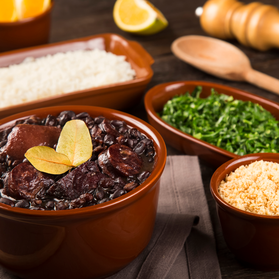Feijoada, um ensopado brasileiro de feijão preto com linguiça, servido com arroz, verduras e farofa.