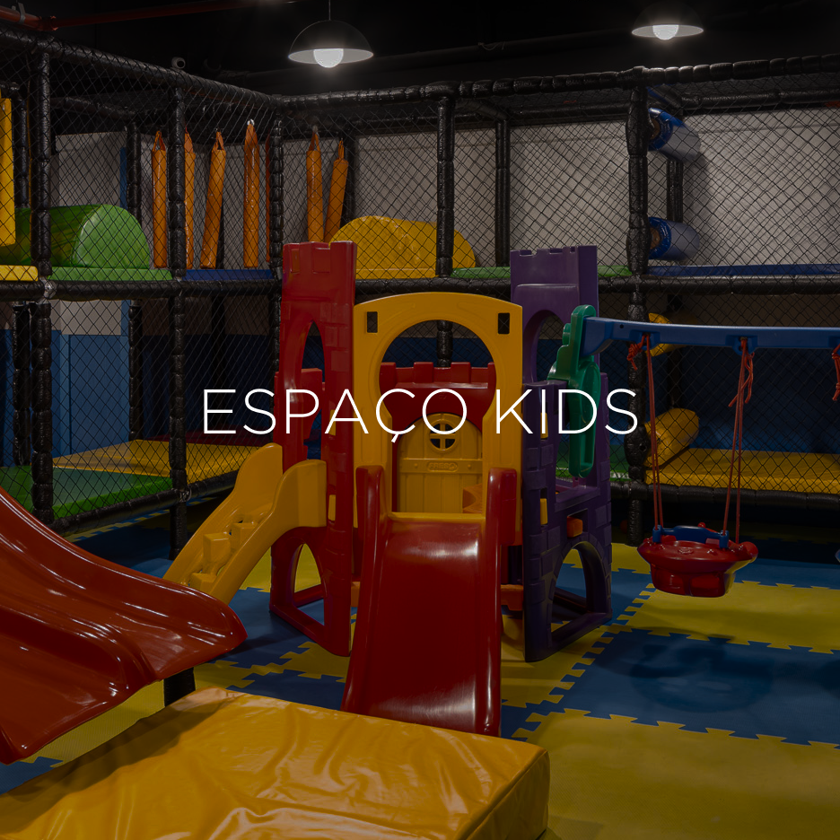 Parque infantil coberto com escorregadores, túneis e uma estrutura em forma de castelo; aparece o texto 