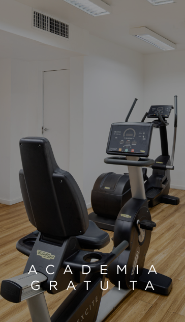 Aparelhos de ginástica em uma academia com piso de madeira e a inscrição 