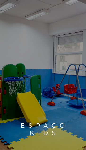 Sala de jogos com escorregador amarelo, cesta de basquete e balanços sobre tapetes azuis e amarelos. Texto 