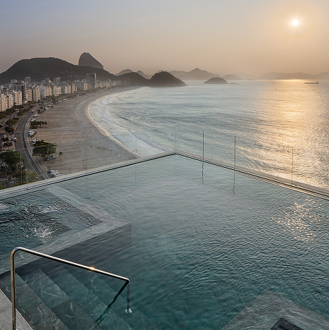 Piscina infinita na cobertura com vista para a praia de Copacabana, no Rio de Janeiro, com vista para as montanhas e o pôr do sol.