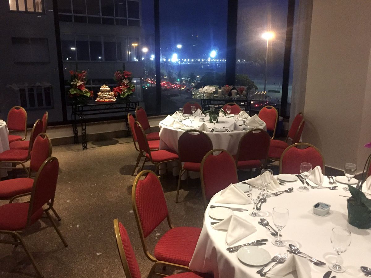 Uma sala com mesas e cadeiras preparada para uma festa