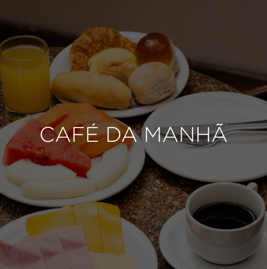 Café da manhã completo com café, suco, doces, frutas e presunto.