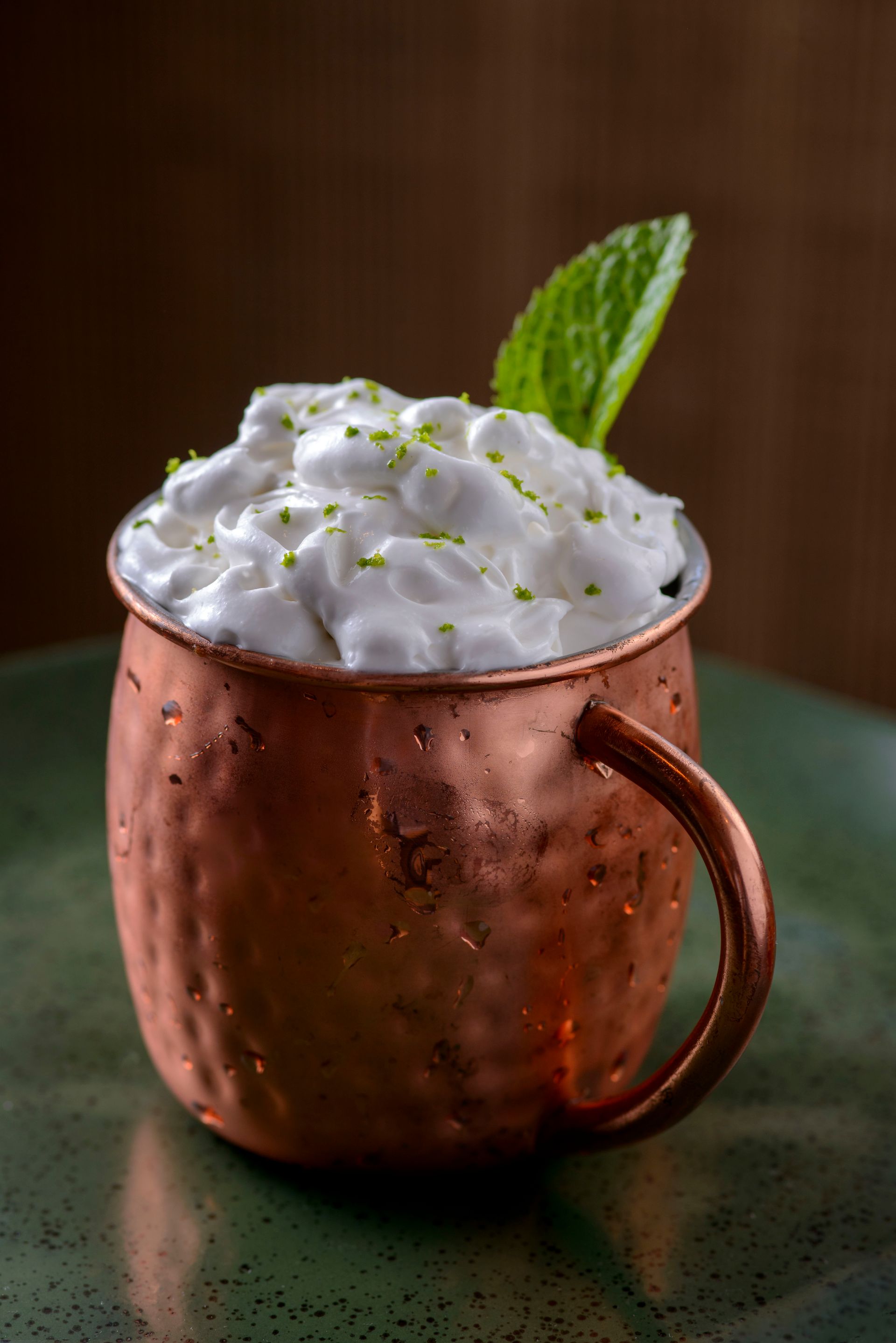 Um close de uma bebida em um copo sobre uma mesa.