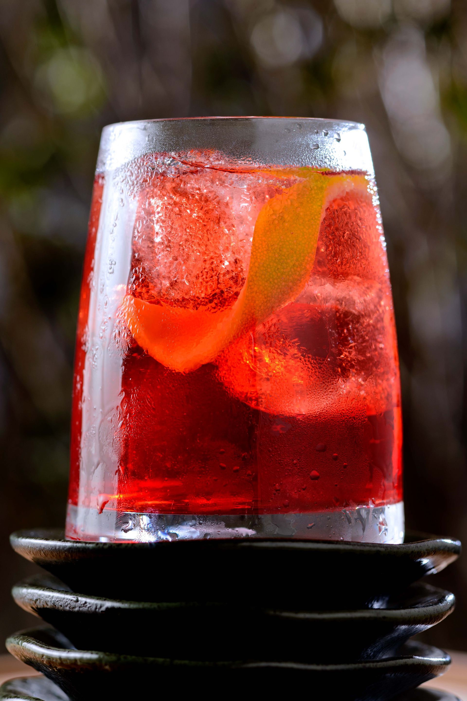 Um copo com um líquido vermelho está em cima de uma pilha de pratos.