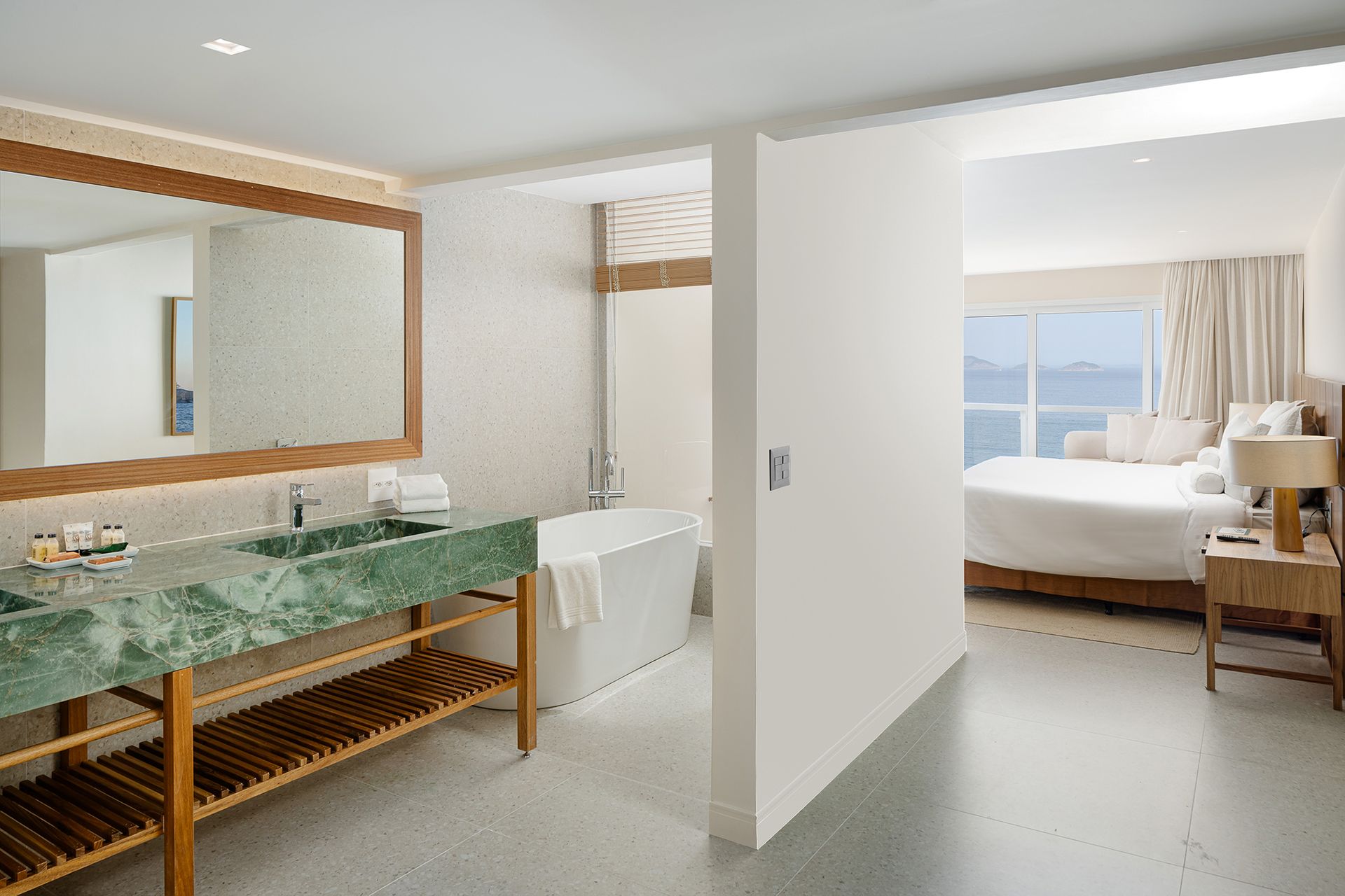 Uma pessoa está servindo champanhe em uma taça sobre uma mesa com pétalas de rosa.