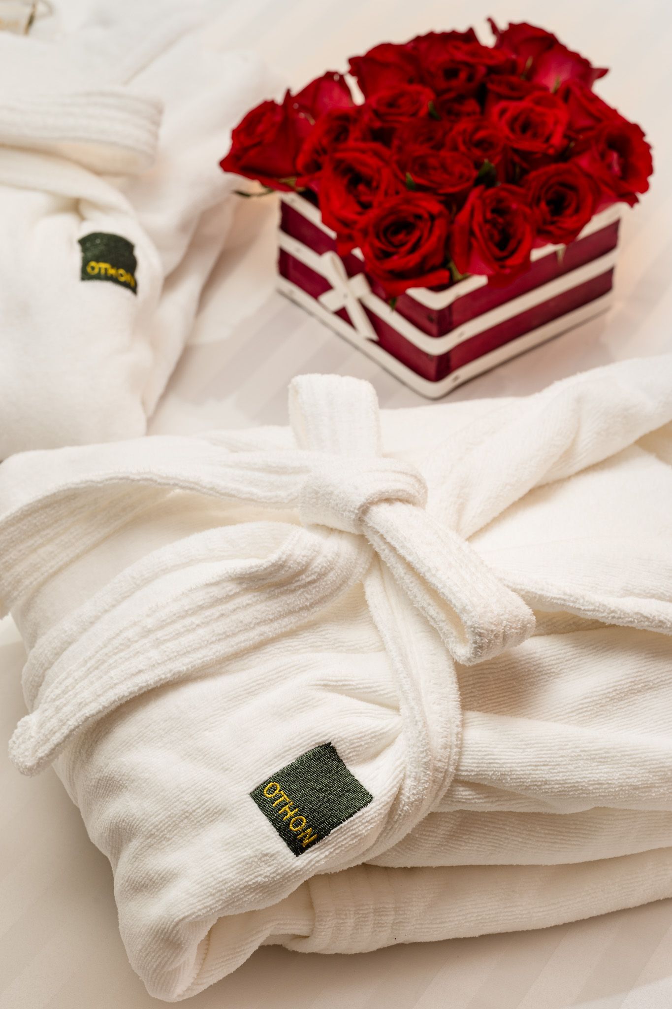 Há um vaso de rosas vermelhas na cama.