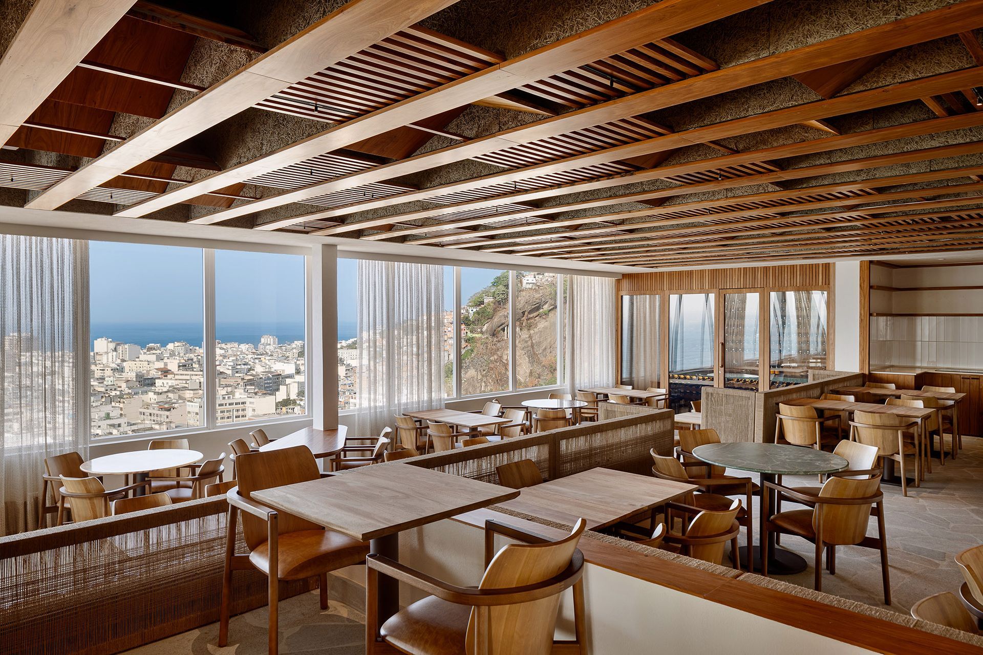 Um restaurante com mesas e cadeiras e vista para o oceano