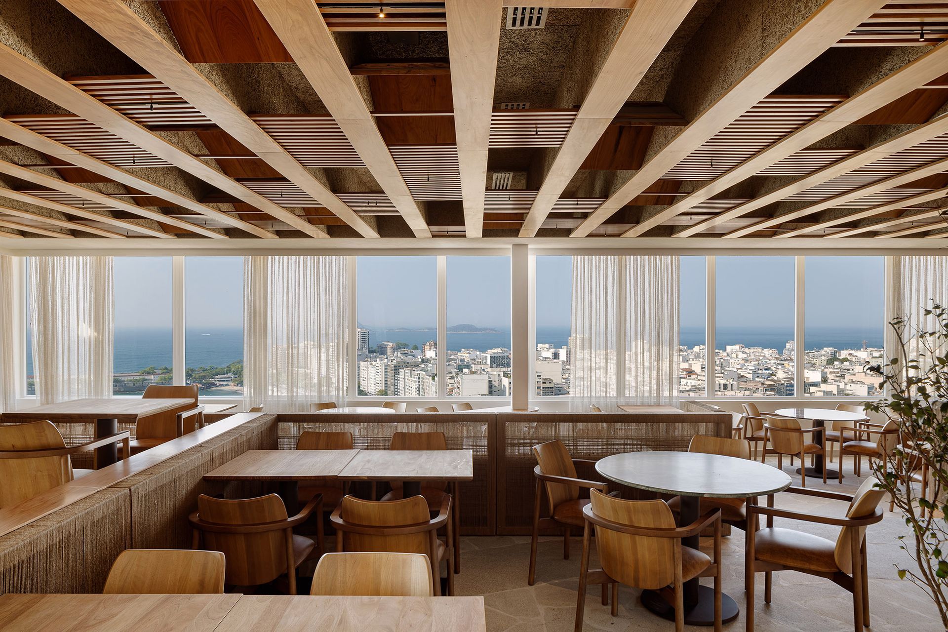 Um restaurante com mesas e cadeiras e vista para o oceano