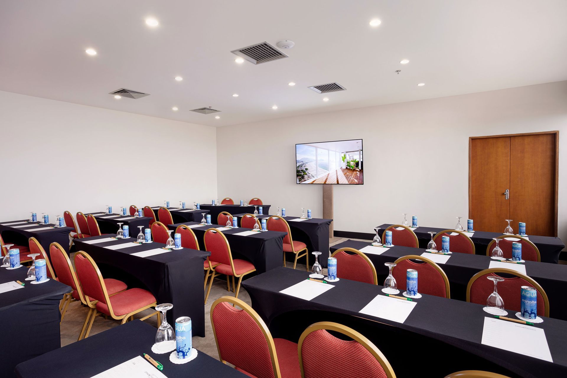 Uma sala de conferências com mesas e cadeiras preparadas para uma reunião