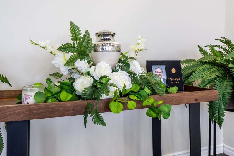 A wooden table with flowers and a picture on it.
