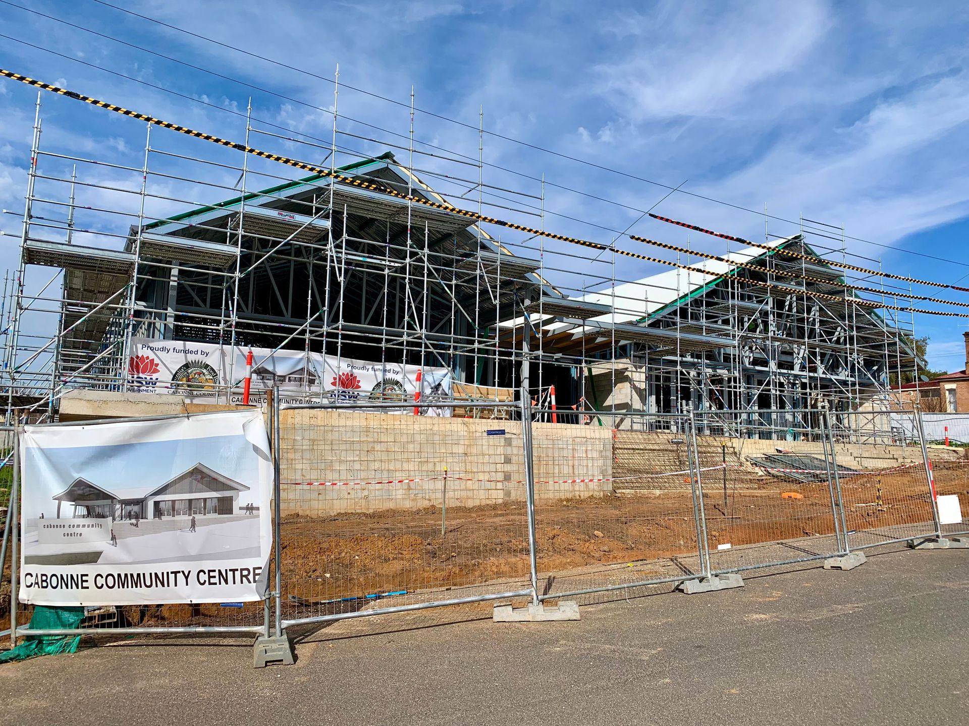 A Construction Site With Scaffolding and a Sign That Says Community Centre — One Group Industries Pty Ltd in Bathurst, NSW