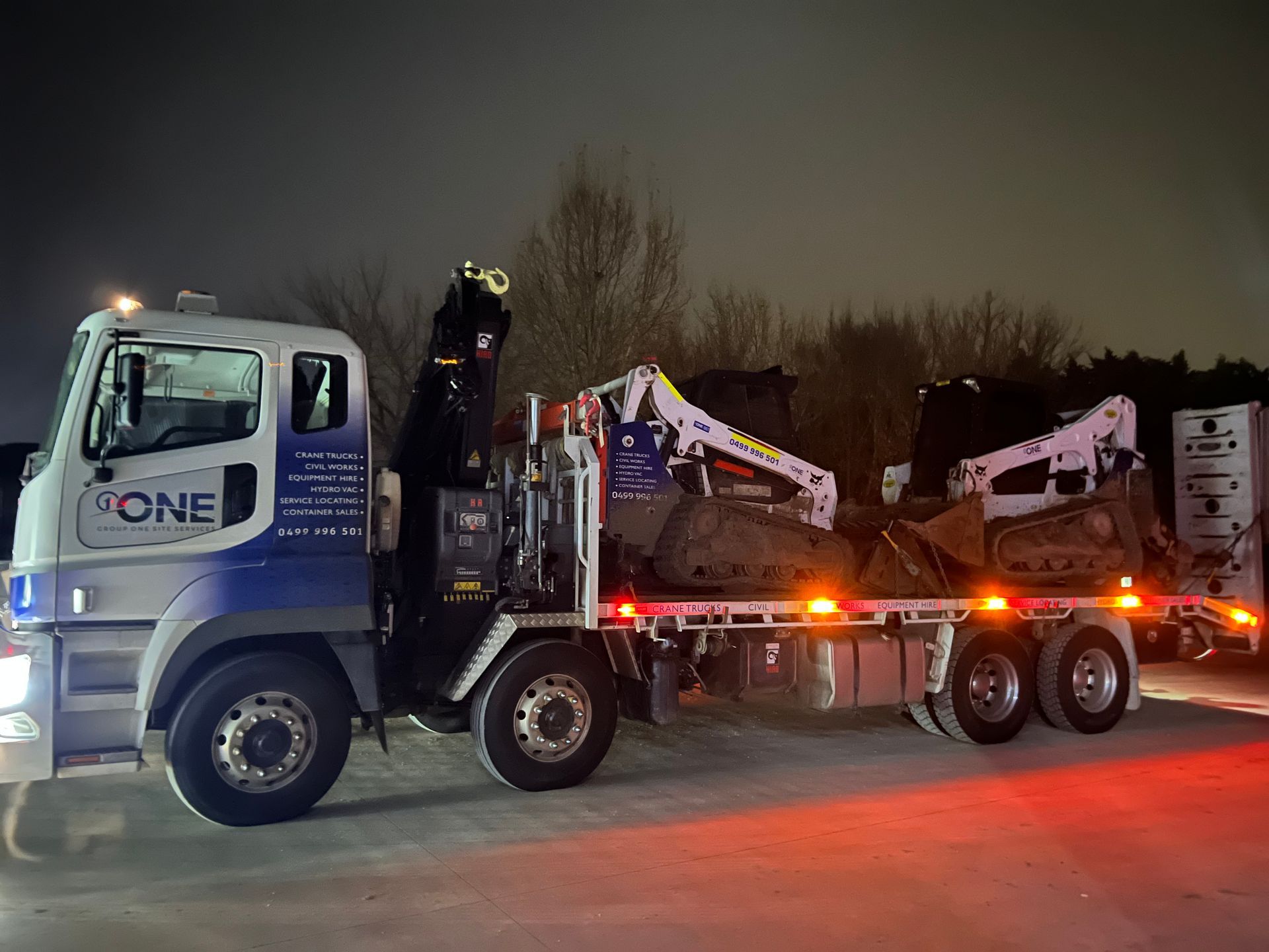 A Truck is Carrying a Bulldozer on a Trailer at Night — One Group Industries Pty Ltd in Bathurst, NSW