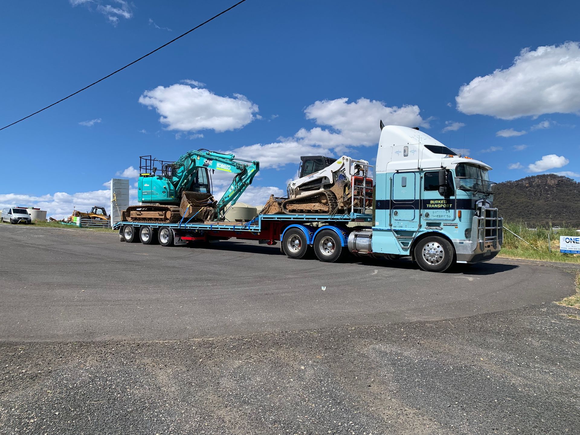 A Semi Truck is Carrying a Bulldozer on a Flatbed Trailer — One Group Industries Pty Ltd in Bathurst, NSW