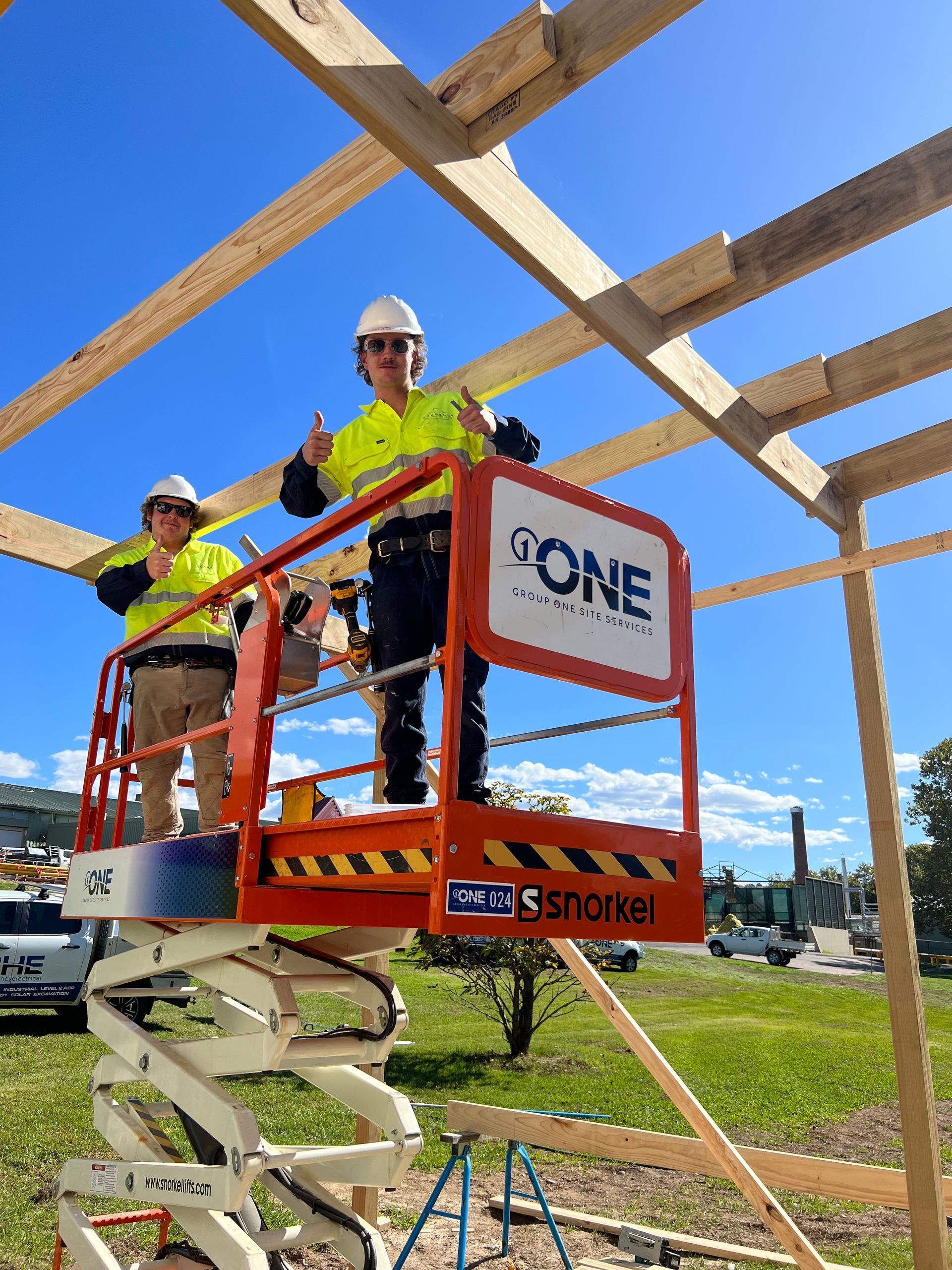Two Construction Workers Are Standing on a Scissor Lift That Says Gone — One Group Industries Pty Ltd in Bathurst, NSW