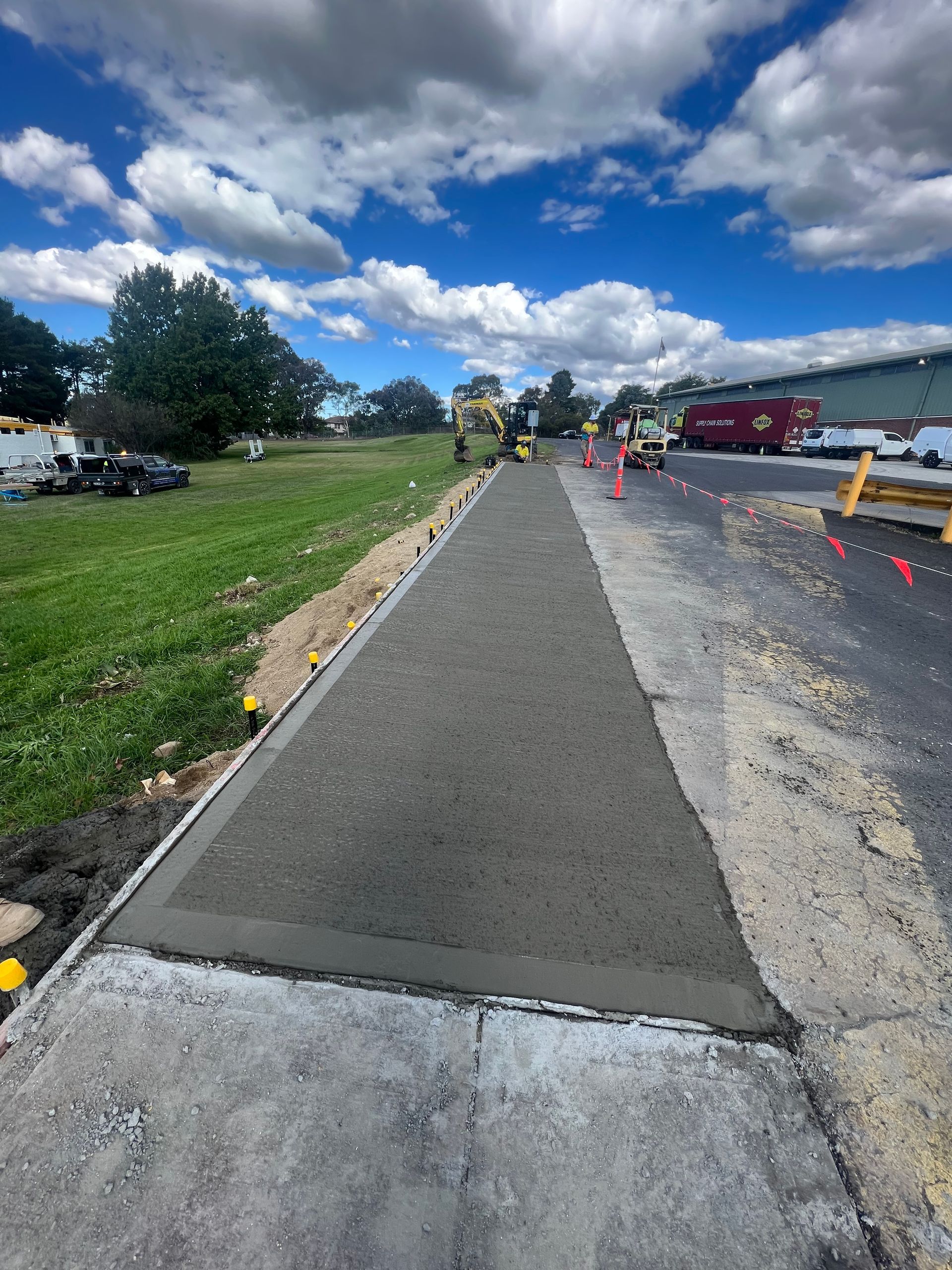 A Concrete Walkway is Being Built Next to a Grassy Field — One Group Industries Pty Ltd in Bathurst, NSW