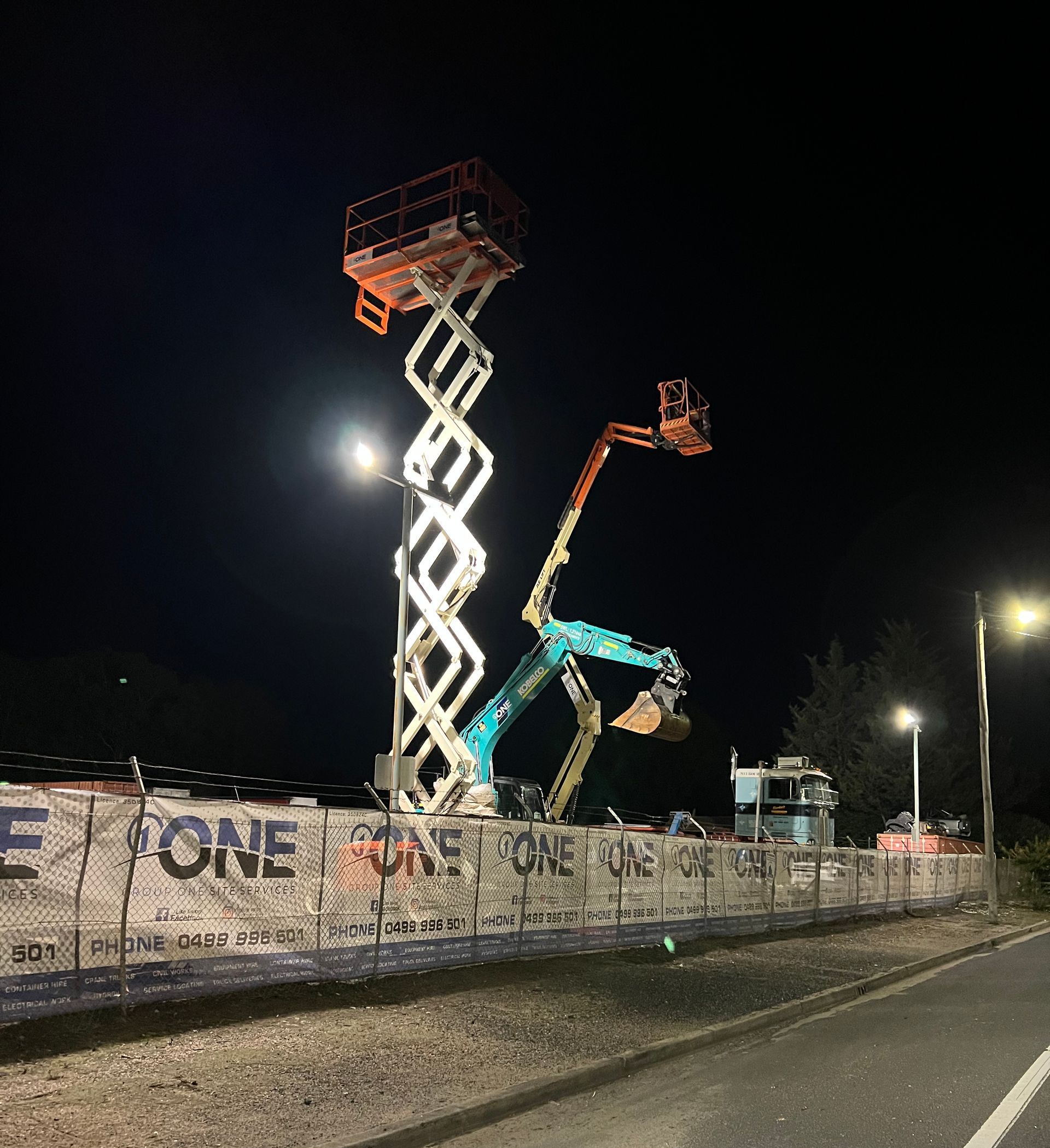 A Construction Site at Night With a Sign That Says One — One Group Industries Pty Ltd in Bathurst, NSW