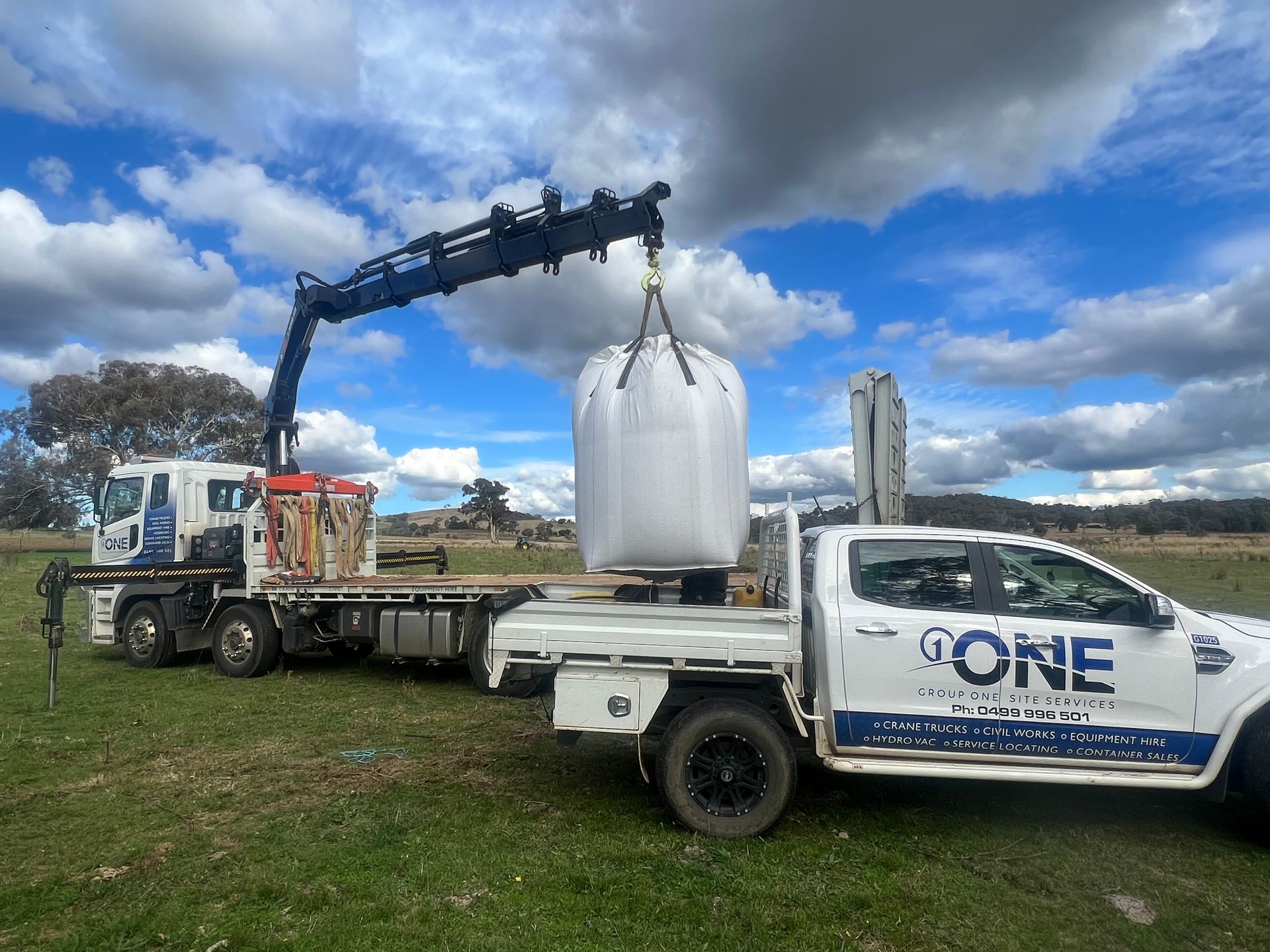 A Truck With a Crane Attached to It is Carrying a Large Bag — One Group Industries Pty Ltd in Bathurst, NSW
