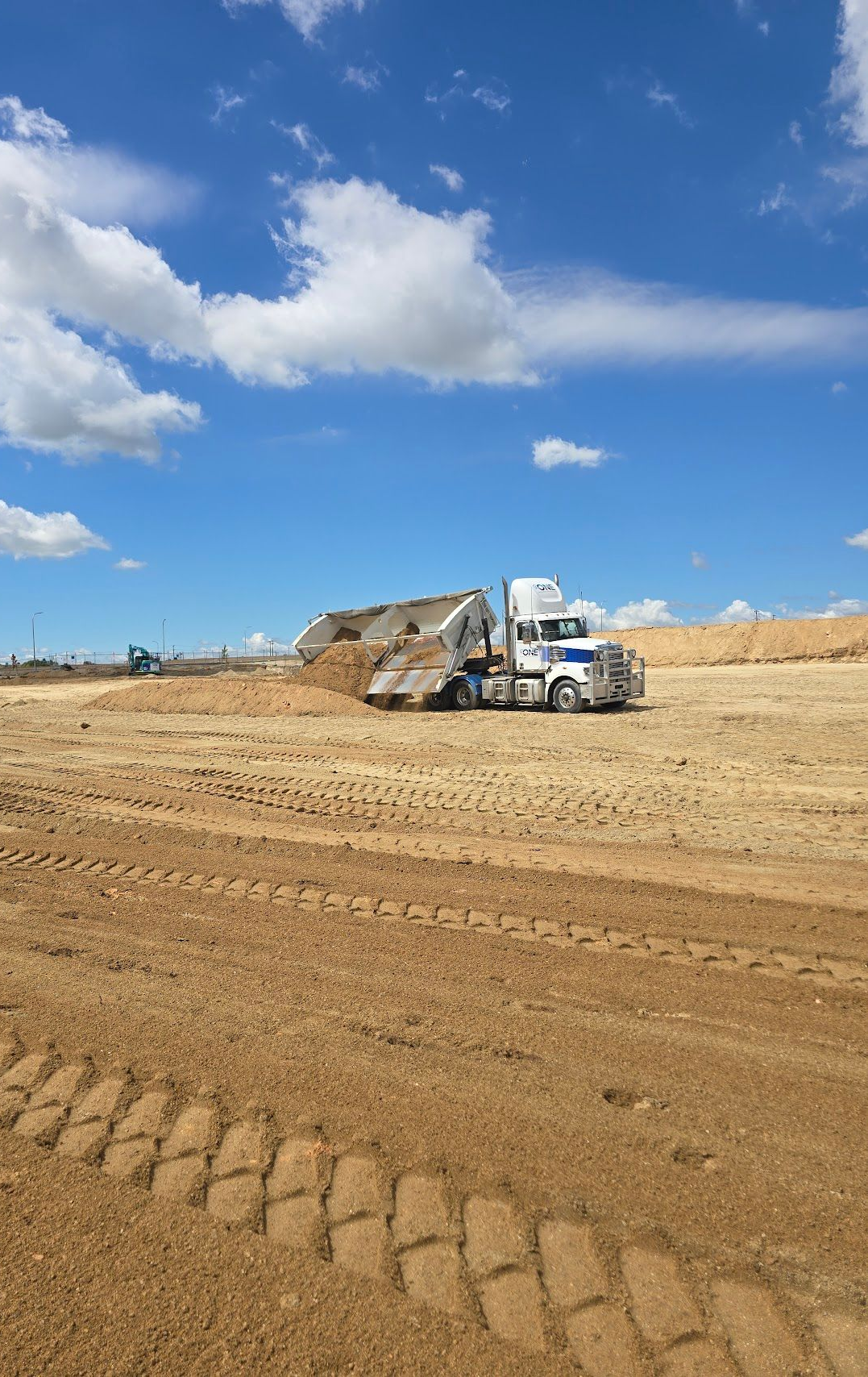 White dump truck unloading material on a construction site — One Group Industries Pty Ltd in Bathurst, NSW