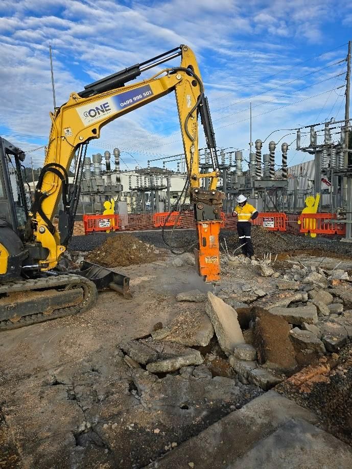 An Excavator Breaks Concrete in A Construction Site — One Group Industries Pty Ltd in Bathurst, NSW