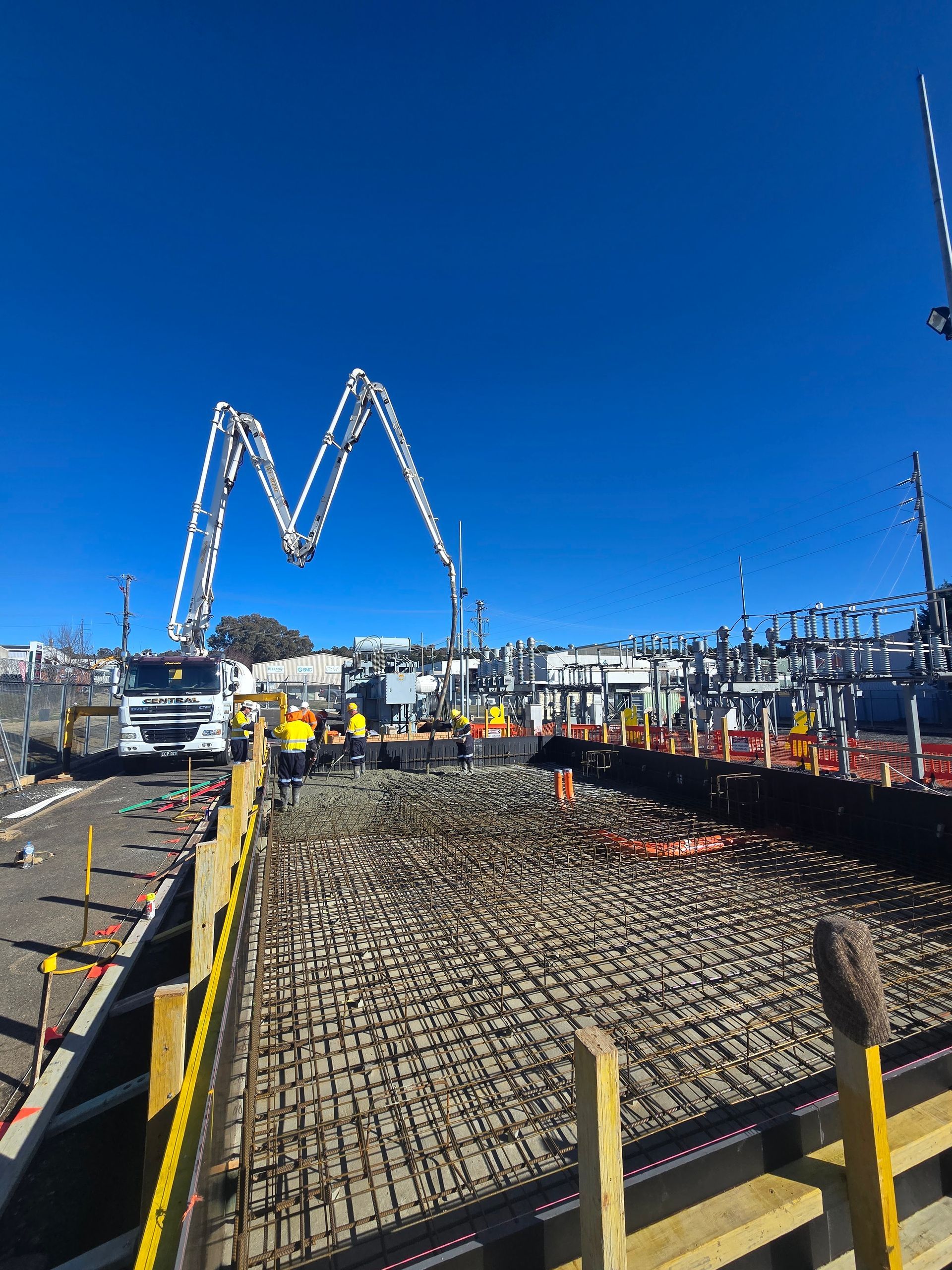 Construction site with concrete forms, rebar, pump truck, and workers — One Group Industries Pty Ltd in Bathurst, NSW