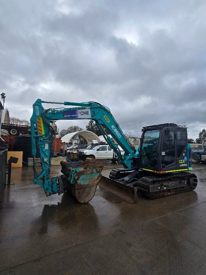 A Excavator Sits on A Wet Concrete Surface — One Group Industries Pty Ltd in Bathurst, NSW.