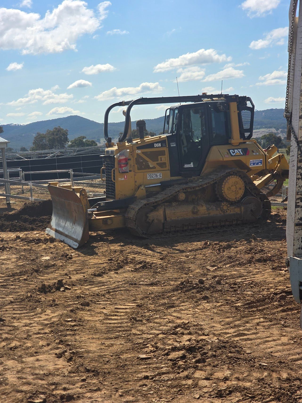 Yellow bulldozer on a construction site with a blue sky and hills in the background — One Group Industries Pty Ltd in Bathurst, NSW