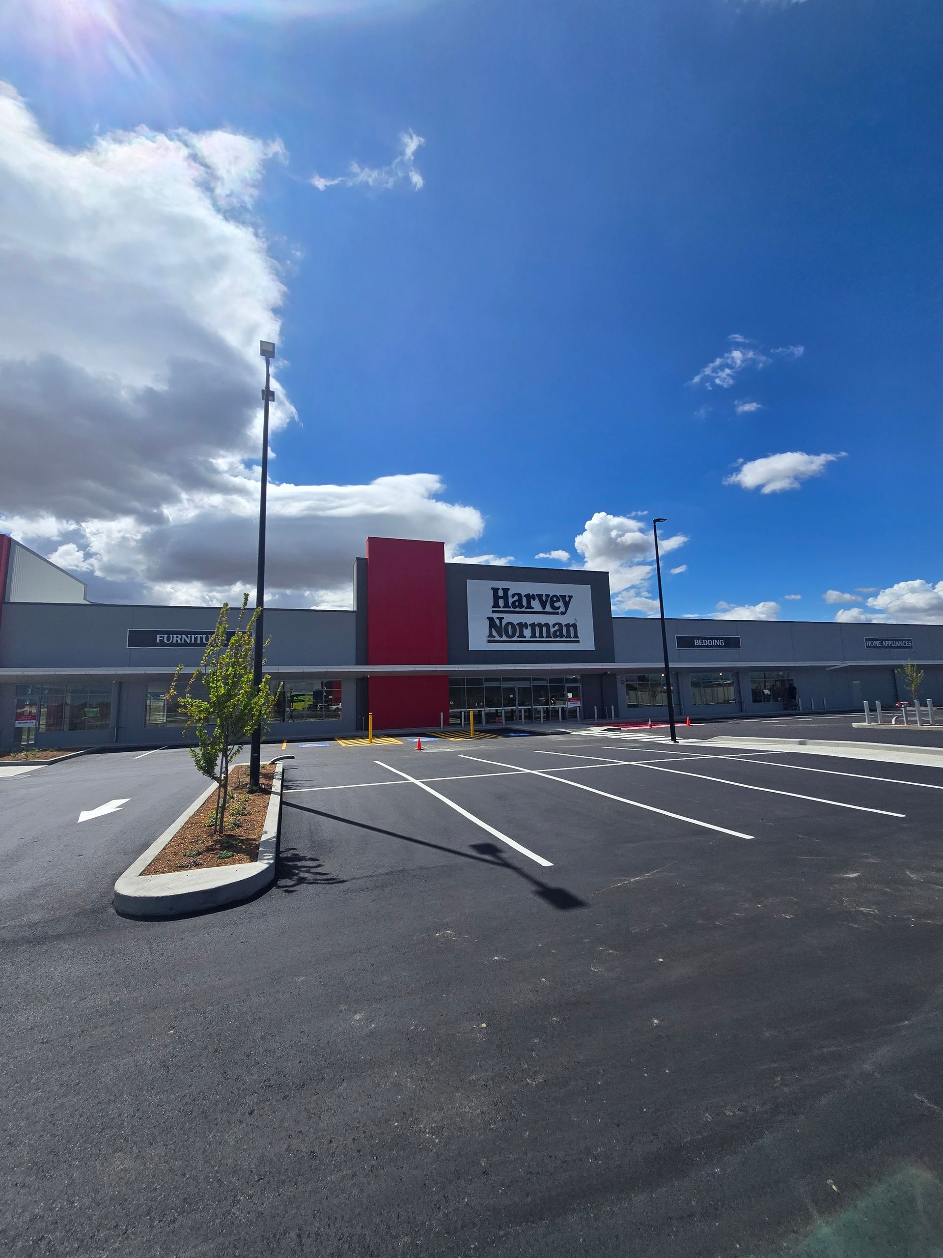 A Pneumatic Tire Roller Compacts Fresh Black Asphalt on A Paved Road — One Group Industries Pty Ltd in Bathurst, NSW