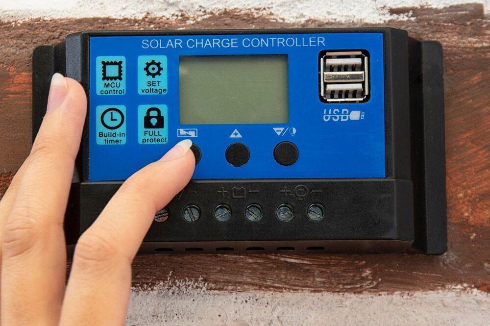 A Person is Pressing a Button on a Solar Charge Controller — One Group Industries Pty Ltd in Bathurst, NSW