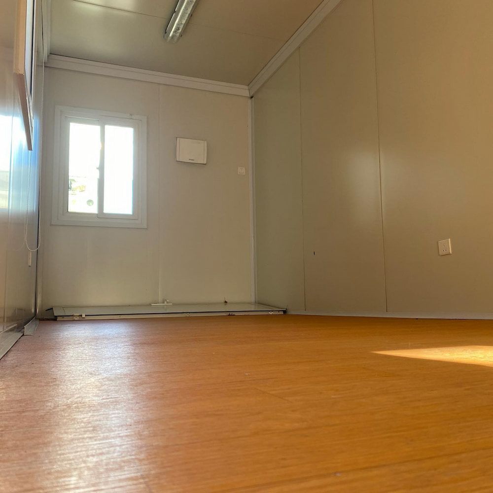 An Empty Room With a Wooden Floor and a Window — One Group Industries Pty Ltd in Bathurst, NSW