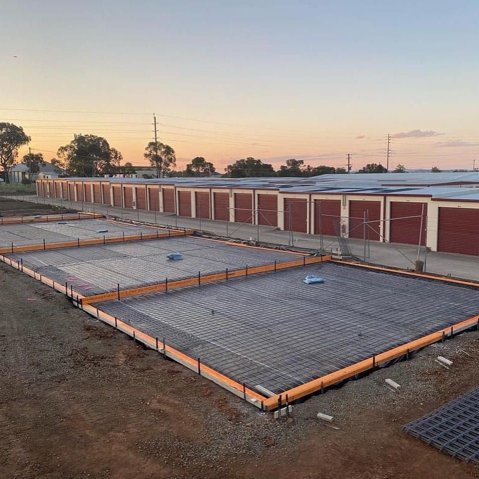 A Large Concrete Slab is Being Built in Front of a Row of Storage Units — One Group Industries Pty Ltd in Bathurst, NSW