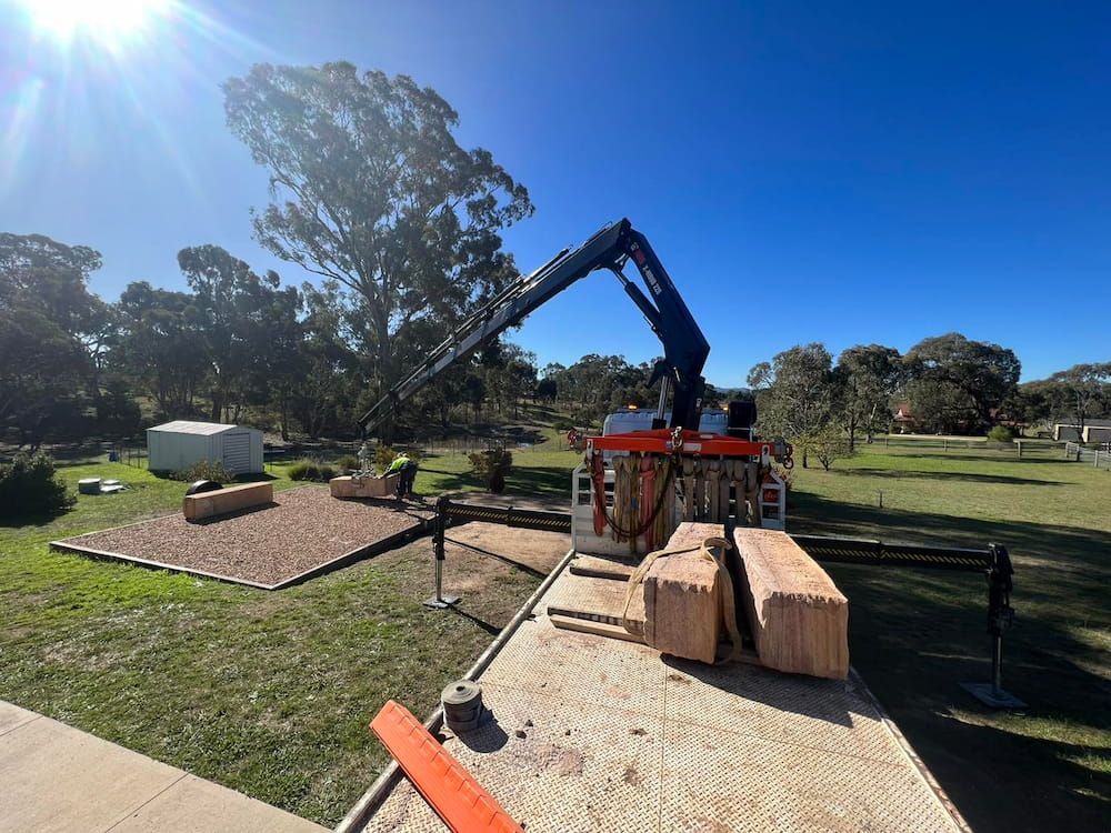 A Crane is Lifting Wooden Blocks From a Truck — One Group Industries Pty Ltd in Bathurst, NSW